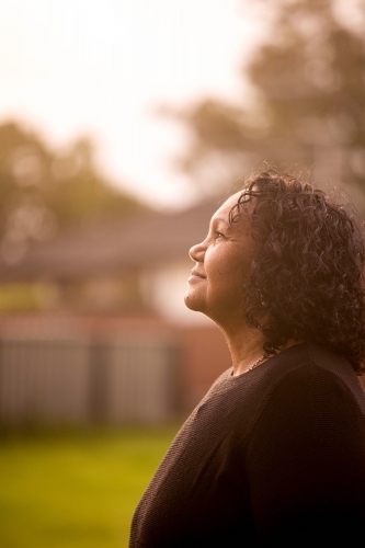 Portrait of Aboriginal woman in backyard - Australian Stock Image