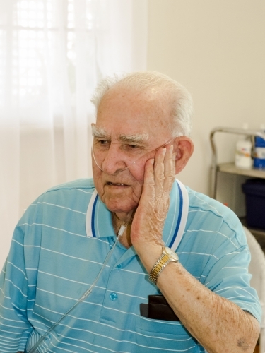 Portrait of an old man with oxygen nose tube in a home - Australian Stock Image