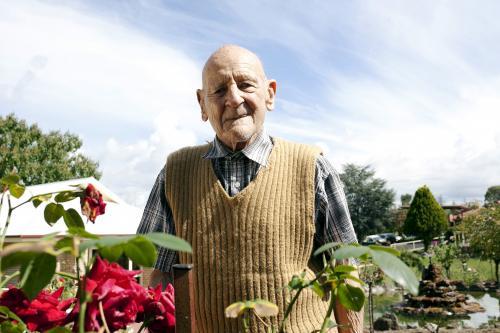 Portrait of elderly man standing in a rose garden at an aged care facility - Australian Stock Image