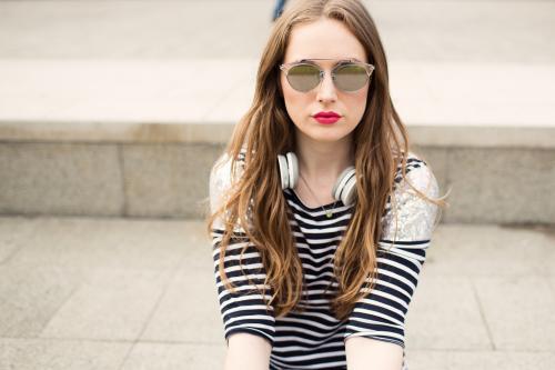 Portrait of fashionable young woman wearing sunglasses sitting down