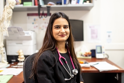 portrait of female doctor sitting in her medical office - Australian Stock Image