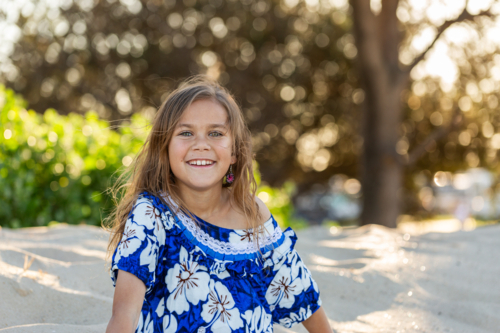 Portrait of First Nations Australian Torres Strait Islander child in traditional floral dress - Australian Stock Image