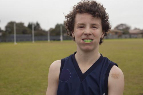 Portrait of Grassroots Footy player smiling with mouthguard - Australian Stock Image