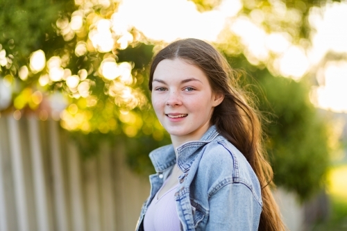 Portrait of happy 14 year old girl with bokeh background - Australian Stock Image