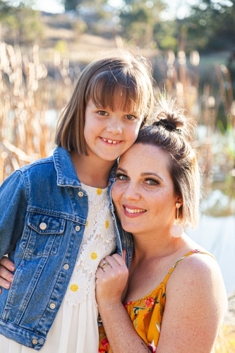 Portrait of happy mother in her thirties with daughter outside - Australian Stock Image