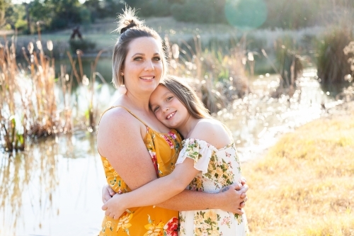 Portrait of happy mother in her thirties with daughter outside - Australian Stock Image