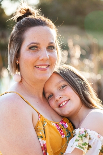 Portrait of happy mother in her thirties with daughter outside - Australian Stock Image
