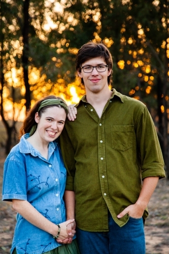 Portrait of happy young engaged couple together outside