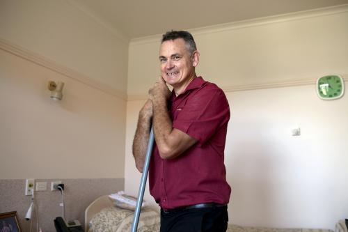 Portrait of Male Nursing Home Staff Member Doing Cleaning Rounds - Australian Stock Image