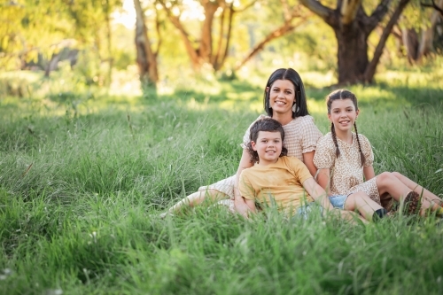 Portrait of mother and children sitting together in Australian bush setting - Australian Stock Image