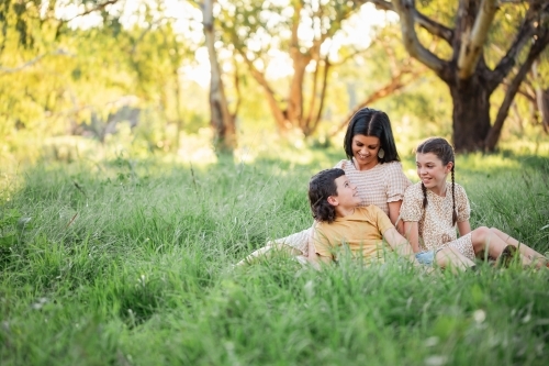 Portrait of mother and children sitting together in Australian bush setting - Australian Stock Image