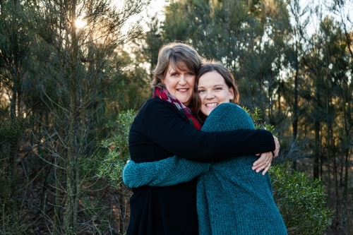 Portrait of mother and daughter embracing in hug - Australian Stock Image