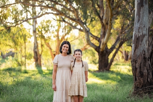 Portrait of mother and daughter standing together in Australian bush setting - Australian Stock Image