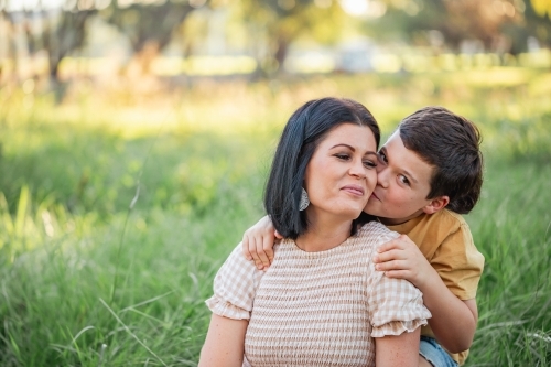 Portrait of mother and son sitting together in Australian bush setting - Australian Stock Image