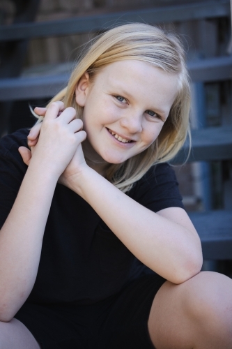 Portrait of pre-teen boy with long blonde hair and blue eyes. Happy expression with big smile - Australian Stock Image