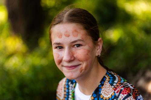 Portrait of pre-teen First Nations Australian girl in traditional aboriginal ochre face paint - Australian Stock Image