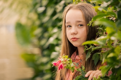 Portrait of pre-teen girl in lush garden setting - Australian Stock Image