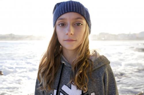 Portrait of pre-teen girl with beanie standing by the ocean - Australian Stock Image