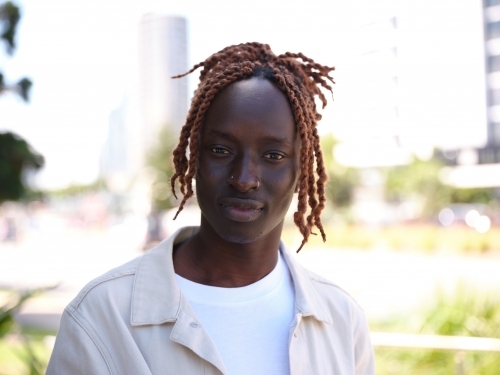 Portrait of Sudanese man wearing a jacket outside - Australian Stock Image