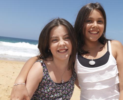Portrait of teenage sisters at beach