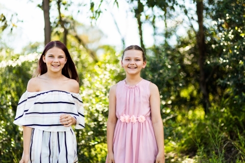 Portrait of tween sisters with natural outdoor background