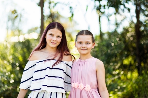 Portrait of tween sisters with natural outdoor background