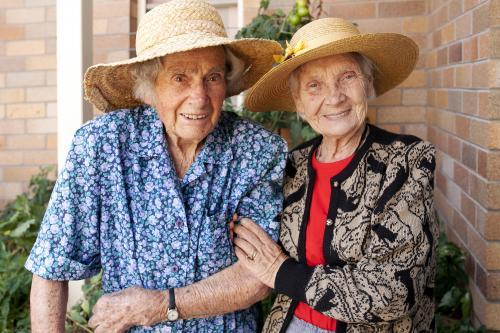 Portrait of two elderly ladies walking in the garden at an aged care facility