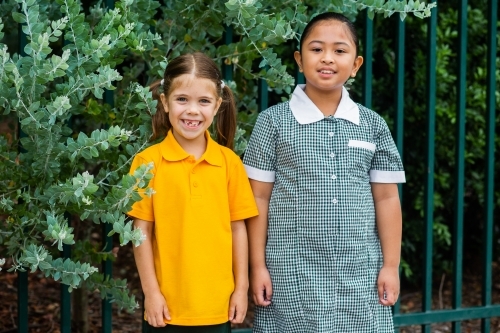 Portrait of two happy school girls looking forward to going back to school - Australian Stock Image