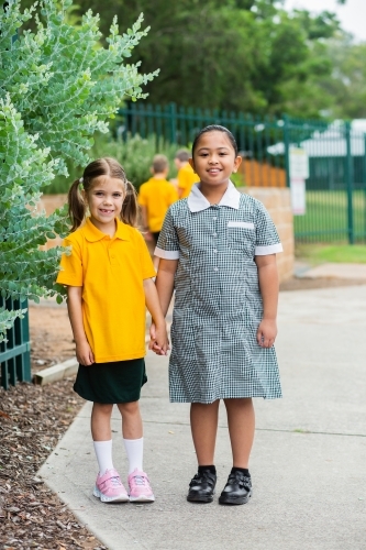 Portrait of two happy school girls looking forward to going back to school - Australian Stock Image