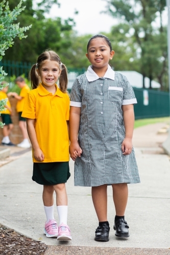 Portrait of two happy school girls looking forward to going back to school - Australian Stock Image