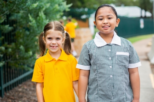 Portrait of two happy school girls looking forward to going back to school - Australian Stock Image