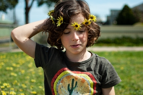 Portrait of young child wearing a daisy chain made of capeweed