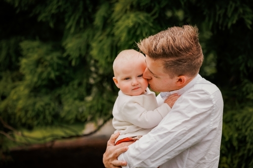 Portrait of young Dad and small baby in the park - Australian Stock Image