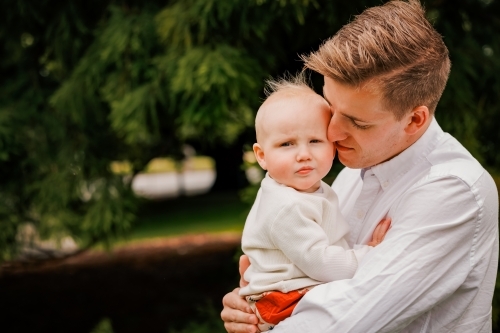 Portrait of young Dad and small baby in the park - Australian Stock Image