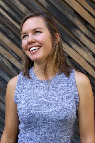 Portrait of young female outdoors with textured wooden background - Australian Stock Image