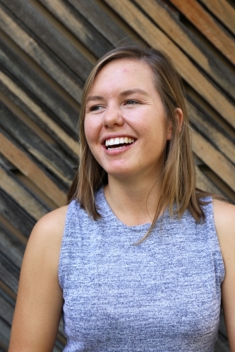 Portrait of young female outdoors with textured wooden background - Australian Stock Image