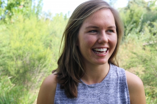 Portrait of young female outdoors with trees in background - Australian Stock Image
