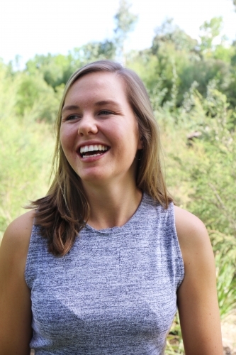 Portrait of young female outdoors with trees in background - Australian Stock Image