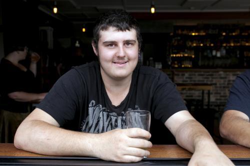 Portrait of young man having a drink at pub - Australian Stock Image