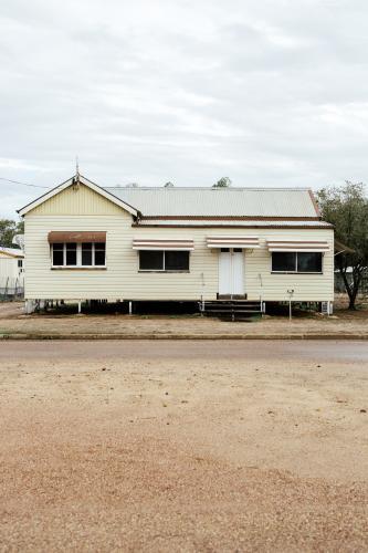 Portrait photo of cream coloured Queenslander House with brown trimming - Australian Stock Image