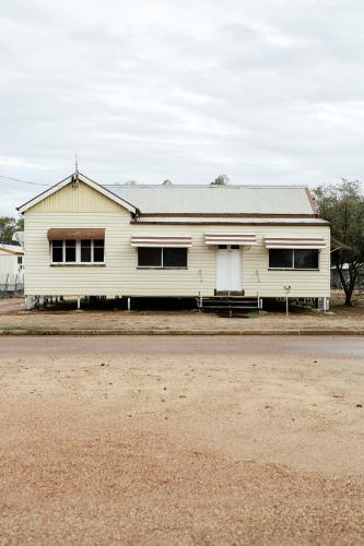 Portrait photo of cream coloured Queenslander House with brown trimming