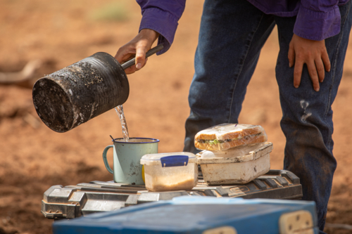 Pouring a cup of billy tea or coffee during dinner camp - Australian Stock Image