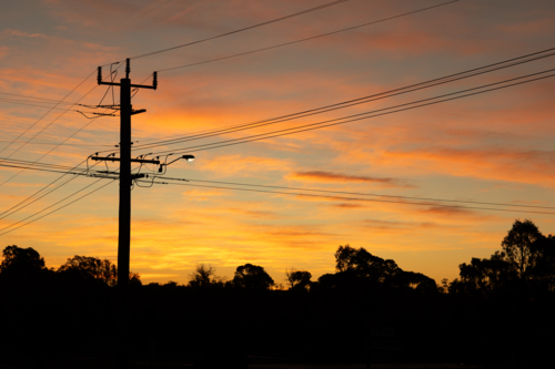 power lines criss-crossing the sky at sunset - Australian Stock Image