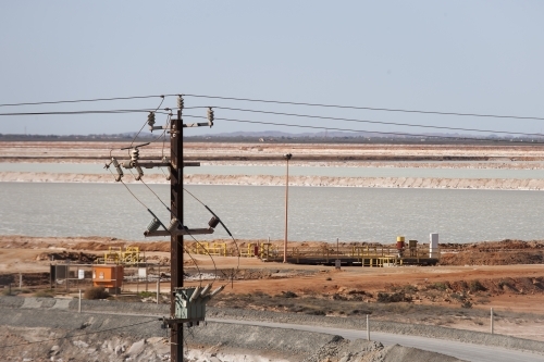 Power pole with industrial site in background - Australian Stock Image