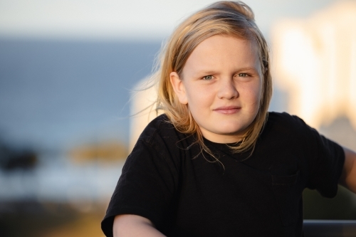 Pre-teen boy standing on balcony of high rise building on the Gold Coast with view - Australian Stock Image