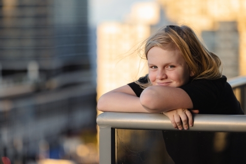Pre-teen boy standing on balcony of high rise building on the Gold Coast with view of Surfers Paradi - Australian Stock Image