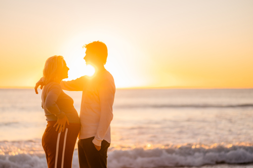 Pregnant couple enjoying sunrise at Manly Beach - Australian Stock Image