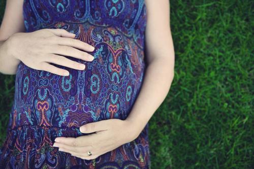 Pregnant Mother relaxing on grass - Australian Stock Image