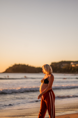pregnant woman by the beach at sunrise - Australian Stock Image