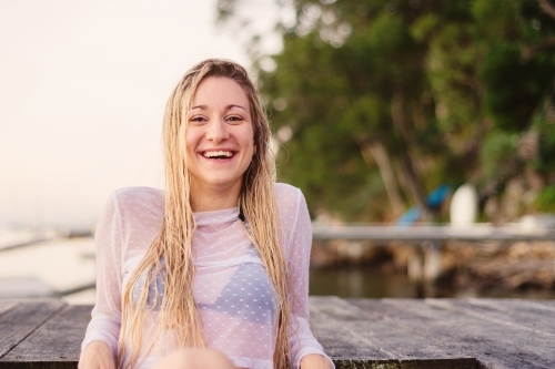 pretty model sitting on jetty - Australian Stock Image